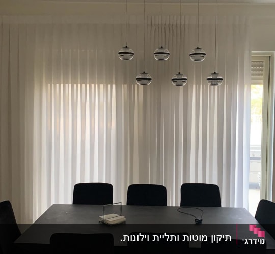 וילון לבן שקוף תלוי על חלון גדול